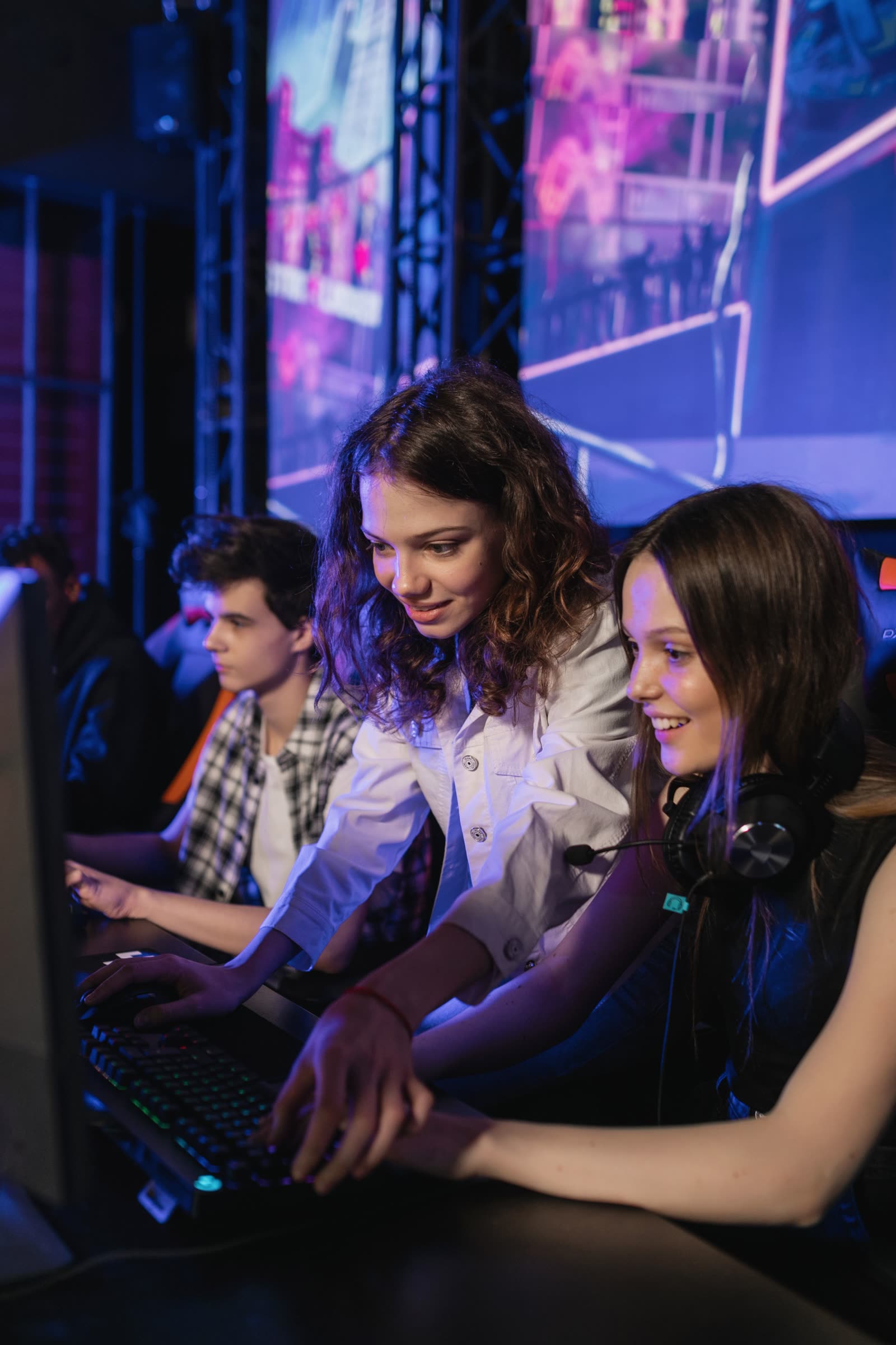 Two players sharing a station side by side under neon light at the NOPING computer club